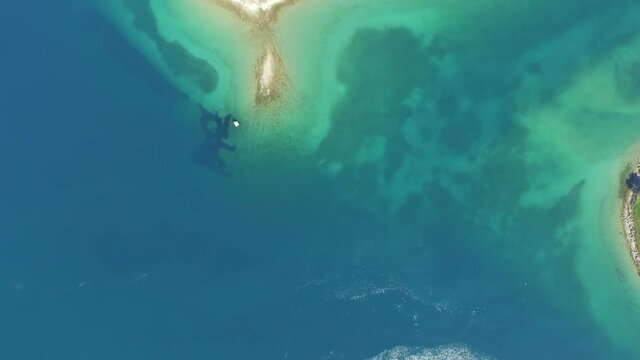 Aerial shot of beacon moored near heart shape island in blue ocean, drone flying over sea on sunny day - Biograd, Croatia