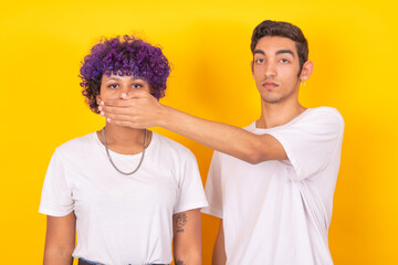 couple of man and woman covering each other's mouth isolated on background - obrazy, fototapety, plakaty