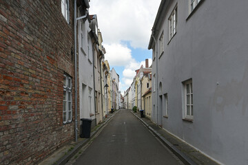 Typical narrow alley with residential buildings in the old town of the hanseatic city Luebeck, Germany