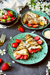 Pancakes with strawberries and chocolate. Spring still life with a sweet breakfast.