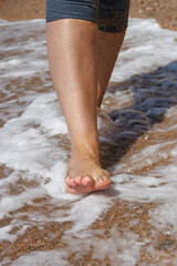 Walk on the sand, on the beach, on the beach. Health. Close-up of a woman's legs.