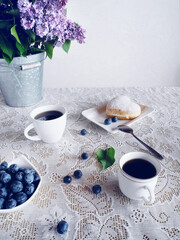 Morning still life with blueberries and coffee. A bouquet of lilacs.
