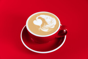 Hot cappuccino on red table with selective focus on the latte art