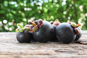 Fresh ripe mangosteen fruits on wooden table.