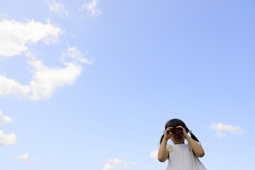 Fototapeta premium オペラグラスを使う幼児(5歳児)と青空