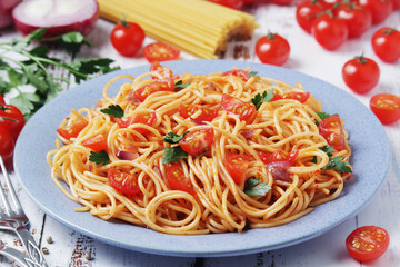 A plate with spaghetti with tomatoes	