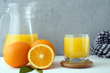 glass of fresh orange juice on the table with a napkin and a jug