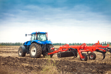 Modern tractor in the field on a bright sunny day.