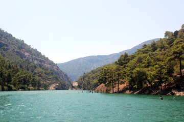 Fototapeta premium Turquoise lake in the middle of green mountains and rocks. Landscape.