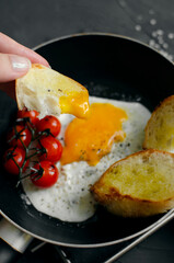 Fried egg in a frying pan with bread