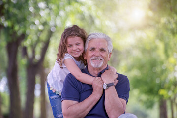 Grandfather and his granddaughter  playing  outdoors
