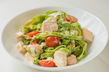 Close Up Spinach Tagliatelle pasta with salmon in cream sauce ready to eat. Mediterranean cuisine.