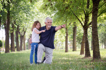 Fototapeta premium Grandfather and his granddaughter playing outdoors