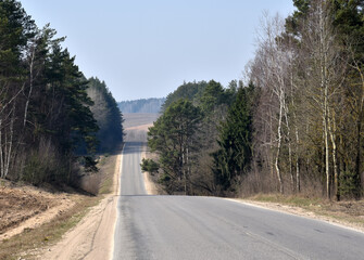 Forest road in mountain district. Empty highway lack of people, cars and vehicles due to quarantine in the context of the coronovirus pandemic COVID-19