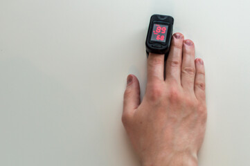 pulse oximeter is placed on the index finger of a man’s hand to measure saturation. Close-up.