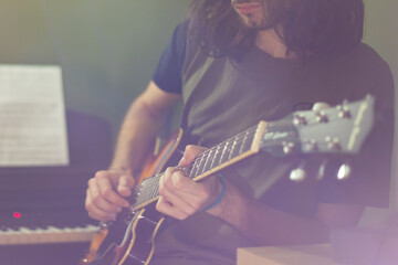 Guitarist playing chords on electric guitar in a recording studio