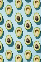 Vertical pattern of cut avocado on blue background, healthy eating concept