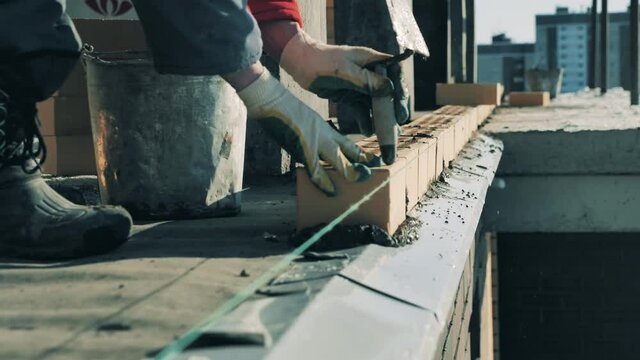 Bricklayer works on construction site.