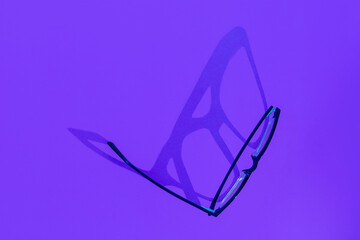 shadow of glasses on a purple background