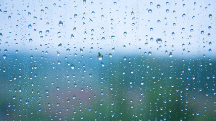Naklejka na ściany i meble raindrops on the glass close-up. Background, texture. Bad weather. Blue tint.