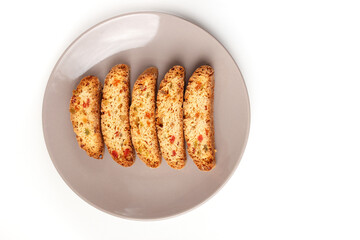 Popular Italian Biscotti or Cantucci biscuit cookies stuffed with candied fruit served on brown plate with copy space.