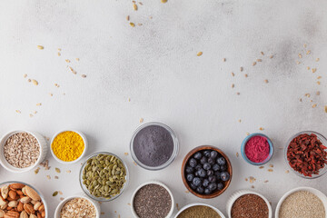 Superfoods on a gray background with copy space. Nuts, berries and seeds. Healthy vegan food.