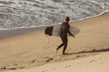 Surfing running on the beach