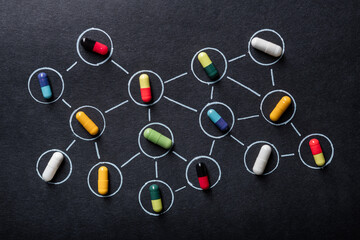 Multicolored capsule pills lie on a white molecular grid