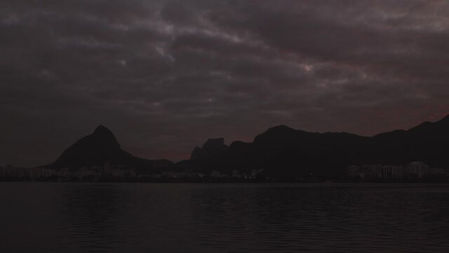 Colourful time lapse of sunset over the city lake Lagoa Rodrigo de Freitas in Rio de Janeiro with the Two Brothers and Gavea mountains in the background