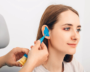 Process of making earplugs from an impression of an individual human ear. Ear close-up. Personally...