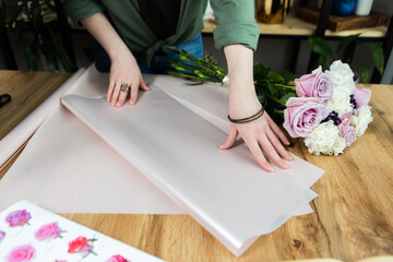 Women's hands with wrapping paper. Decorating in a gift and souvenir shop