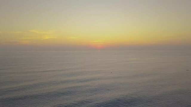 Timelapse soothing view of smooth ocean waves and orange sunset sky horizon. Relaxing nature, surface of the calm sea to orange sky sunset.