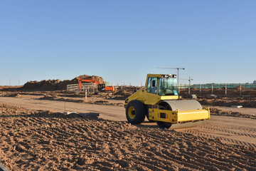 Soil Compactor the leveling soil at construction site. Excavator and vibration single-cylinder road...
