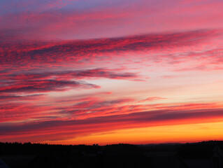 Dramatic sky at sunset, natural color of evening cloudscape with setting sun rays highlighting clouds. Sky and clouds in bright rainbow colors, colorful sky in dusk. Majestic purple sky