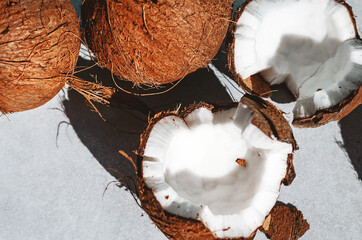 Coconut chopped in half. Top view on a gray background. Exotic fruit. Calorie nut for health and beauty. Selective focus.