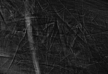 Black aged background. Distressed textile texture. Abstract crumpled scratched surface.