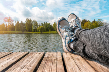 Man with crossed legs relaxing on the wooden jetty