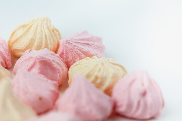 Colorful meringue sweets dessert on white background. Yellow mint green and pink