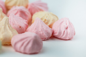 Colorful meringue sweets dessert on white background. Yellow mint green and pink