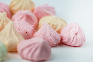 Colorful meringue sweets dessert on white background. Yellow mint green and pink