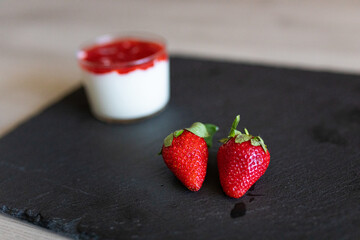 Closeup of some strawberries with a smoothie in the background