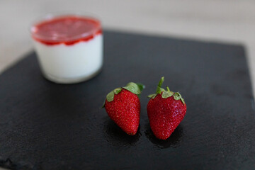 Closeup of some strawberries with a smoothie in the background