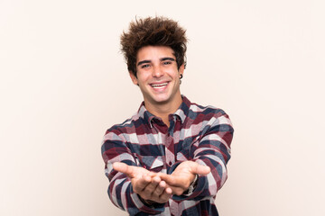 Young caucasian man holding copyspace imaginary on the palm to insert an ad