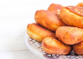 Piroshki - russian baked puff pastry with cabbage fillings. Traditional russian cabbage stuffed baked pastry. lean pies with cabbage. Beautiful homemade cakes with cabbage in metal dishes on white