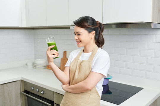 Detox Concept. Close Up Portrait Of Asian Girl Holding Glass With Homemade Green Juice, Looking Aside At Free Space