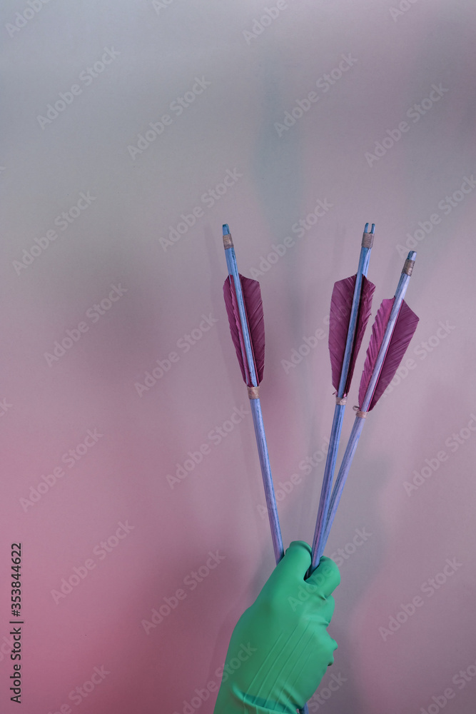 Poster Beautiful hand holding old green arrows in the color light. Beautiful old arrow minimal in neon light. Minimalism retro style concept. Background pattern for design..