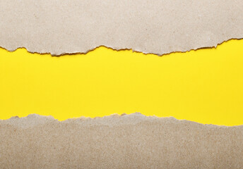 Dark paper with torn edges isolated on a yellow background of colored paper inside. Good paper...