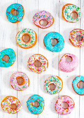 Colorful Donuts turquoise and pink, pattern. Donuts Set on White Background. Doughnuts with multi colored glaze. Doughnuts are traditional sweet pastries. Set of various colorful donuts.