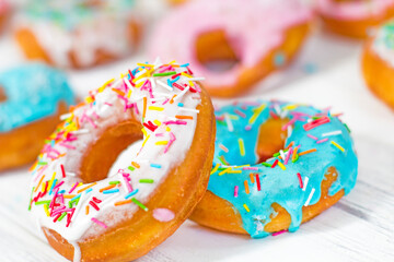 Colorful Donuts turquoise and pink on White Background close-up. Doughnuts with multi colored...