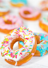 Colorful Donuts turquoise and pink on White Background close-up. Doughnuts with multi colored...